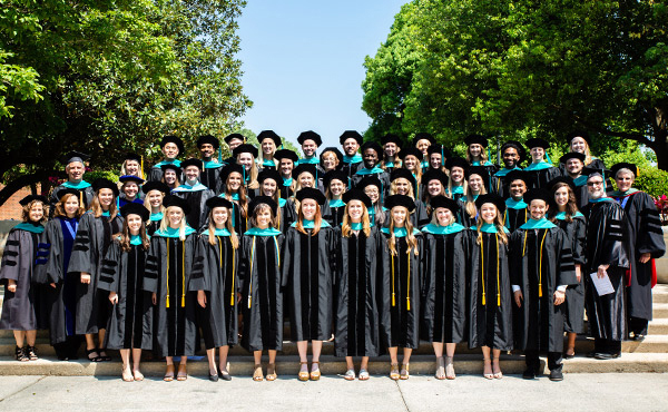 A group of graduates outside gathered on steps