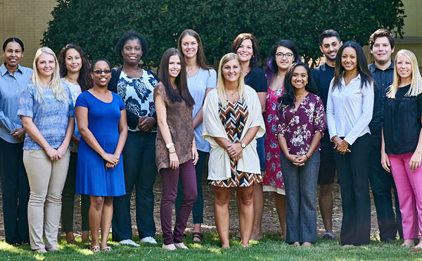 A group of students standing in two rows and smiling