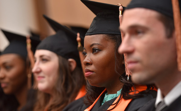 Four students in caps and gowns