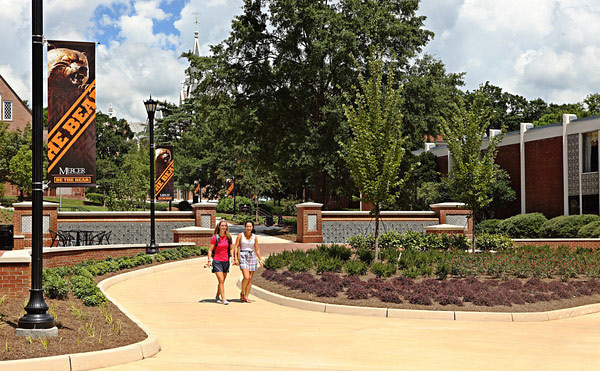 Two students walking in front of the fountains on the Macon campus