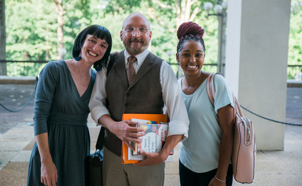 Three people smiling outside on the Atlanta campus